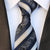 Czarny krawat w białe paski i wzór paisley
